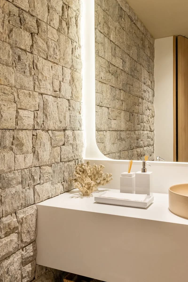 Lavabo com bancada e parede de pedra